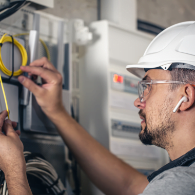 man electrical technician working switchboard with fuses